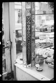 Claudette Joannis photographie Gâteaux exposés à côté d'une vitrine et d'une colonne en miroir gravé d'une boulangerie-pâtisserie, situés près de la porte Ile-de-France, France 1973 Ph.1976.45.62 Photo