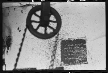 photographie Bastide. Roue du puits et plaque sur l'origine de la citerne Ph.1979.335.4  Photo