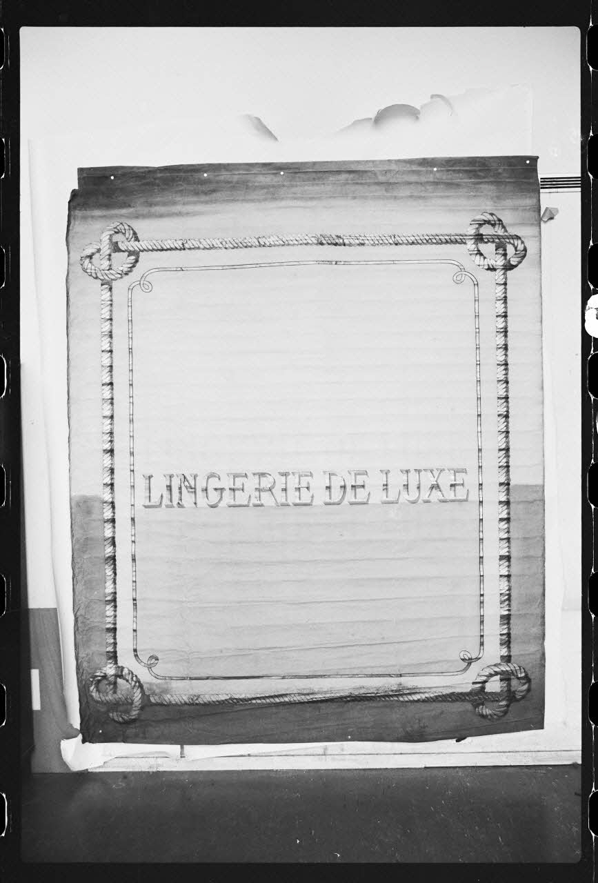 photographie Store en toile peinte de marchand de lingerie en dentelle. 20è siècle Ph.1986.1.299 Photo