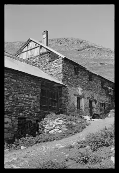 A. Jomelli ; B. Jomelli photographie Le Rivet. Bâtiment avec fenêtre décorée et murs de pierres. La partie haute du mur pignon est faite de planches de bois. Cheminée en bois et en tôle Provence-Alpes-Côte d'Azur, France 1966/7/12 Ph.1966.119.20 Photo