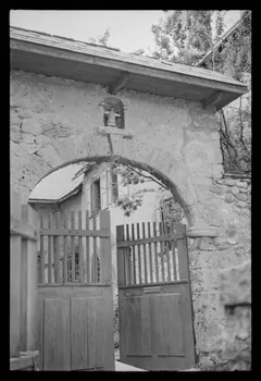 A. Jomelli ; B. Jomelli photographie Entrée du presbytère avec portail et niche abritant une statue polychrome de saint Claude. Deux battants en bois plein et bois à clairevoie ferment la cour Provence-Alpes-Côte d'Azur, France 1966/7/21 Ph.1966.119.73 Photo