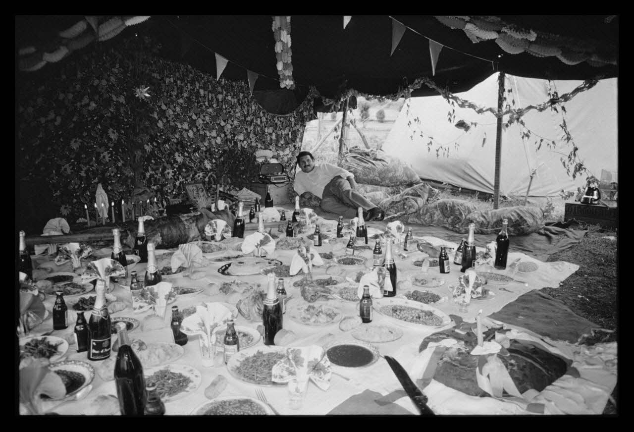 Philippe Lemaire De Marne photographie Roms, nomades "Kalderash". Fête traditionnelle "Prasmiko". Famille de "Papa" Gusman et Théodore Gusman, son frère dans un terrain loué à la sortie du village. Table de Théodore Midi-Pyrénées, France 1965/8/15 Ph.1966.68.74 Photo