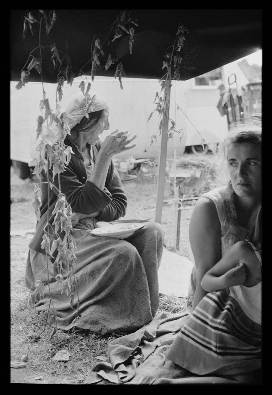 Philippe Lemaire De Marne photographie Roms, nomades "Kalderash". Fête traditionnelle "Prasmiko". Famille de "Papa" Gusman et Théodore Gusman, son frère dans un terrain loué à la sortie du village. Vieille femme : "Milka" Gusman Midi-Pyrénées, France 1965/8/15 Ph.1966.68.80 Photo