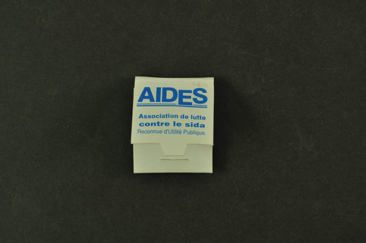 AIDES pin's LE RUBAN ROUGE, // symbole de // solidarité avec // les personnes // atteintes par le  // France 2000/3/30 2002.126.177.1.1-3 Photo Mucem