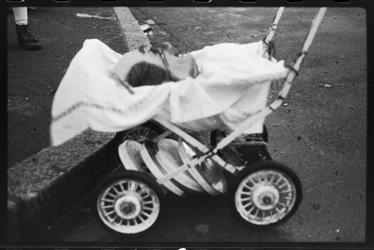 photographie Charivari lors du carnaval et de la mi-carême. Poussette avec des couvercles de casseroles attachés en dessous Ph.1978.35.12  Photo