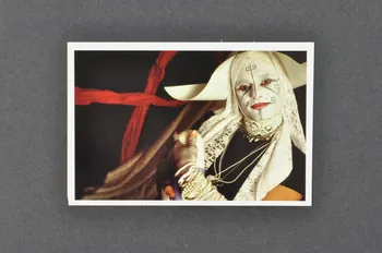 Soeurs de la Perpétuelle Indulgence - San Francisco ; Olivier Touron carte postale "Soeur Sidarta du fond des bois" (1) (soeur tenant dans ses bras une gélule de médicament) France 2001 2002.92.24  Photo Mucem