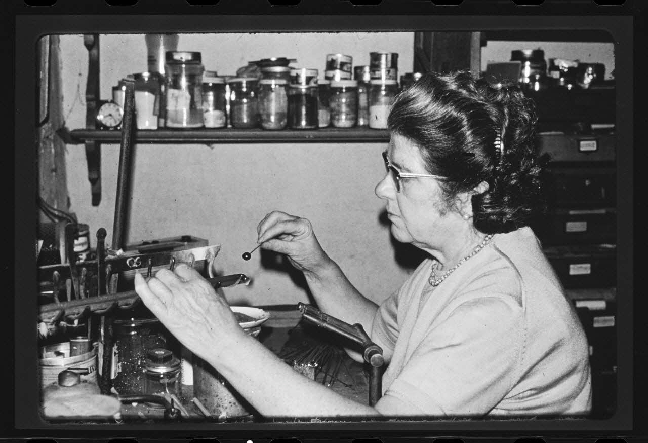 Anonyme photographie Transformation et utilisation du verre. Emailleuse en train de faire des perles artificielles Ile-de-France, France 1967 Ph.1984.27.1 Photo