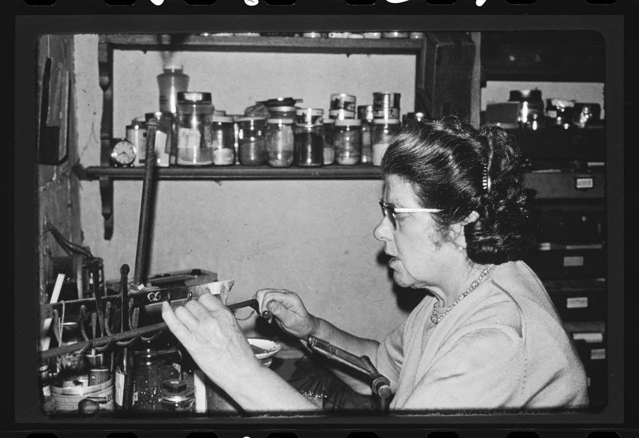Anonyme photographie Transformation et utilisation du verre. Emailleuse en train de faire des perles artificielles Ile-de-France, France 1967 Ph.1984.27.2 Photo