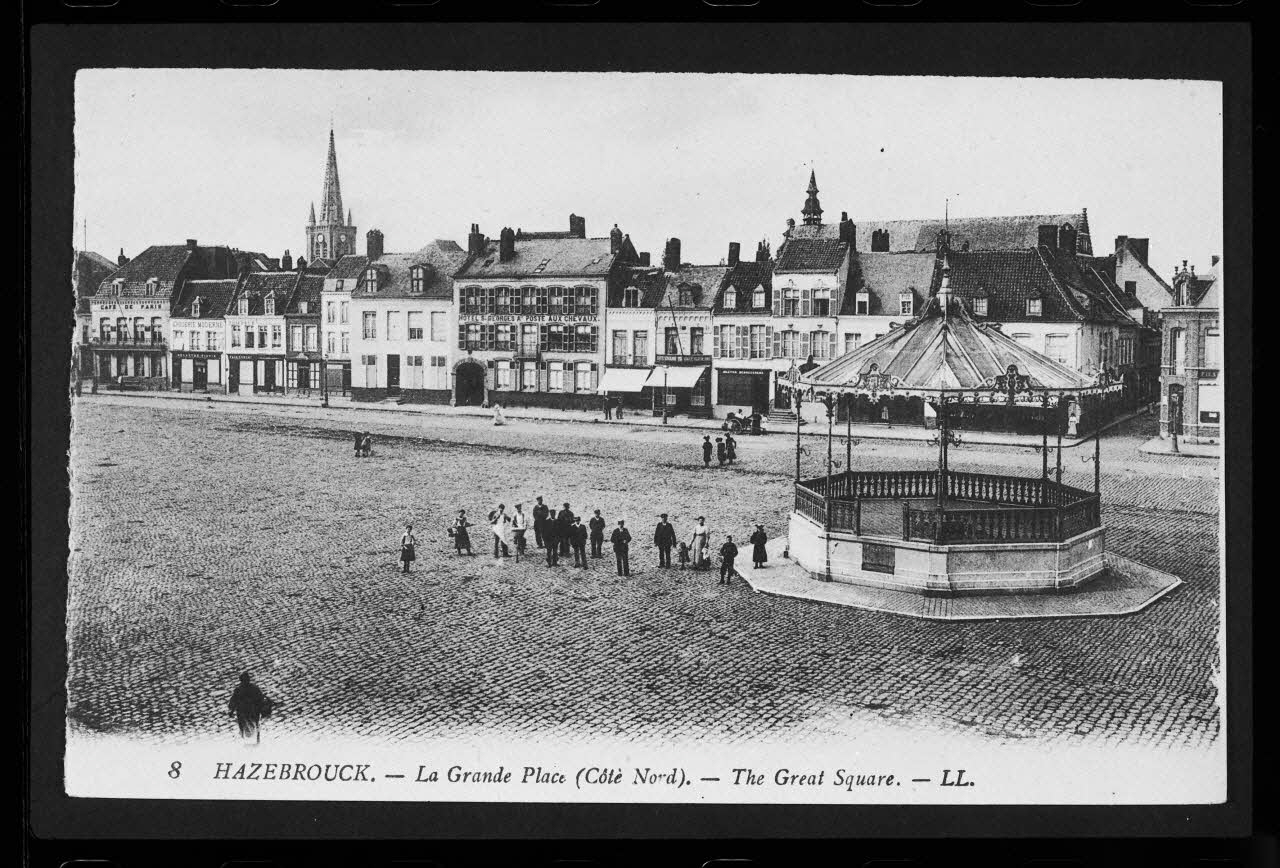 photographie "La grande place. Côté Nord". Carte postale. Edicule avec personnage Ph.1984.100.4  Photo