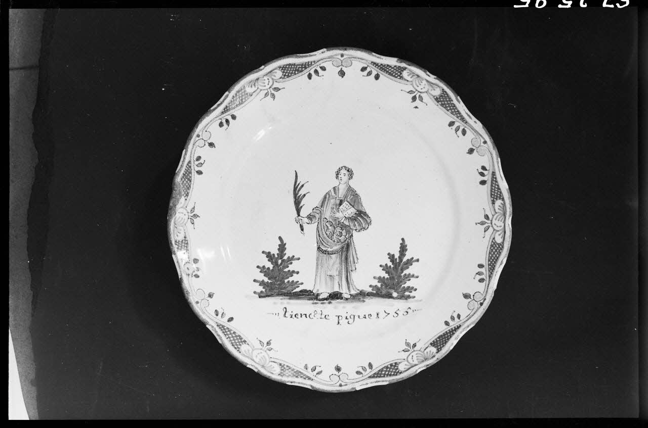 Alain Guey photographie Assiette polychrome avec personnage debout tenant une palme. Inscription "Tiennette Pigue 1755" Ile-de-France, France 1967/3/1 Ph.1967.25.95 Photo