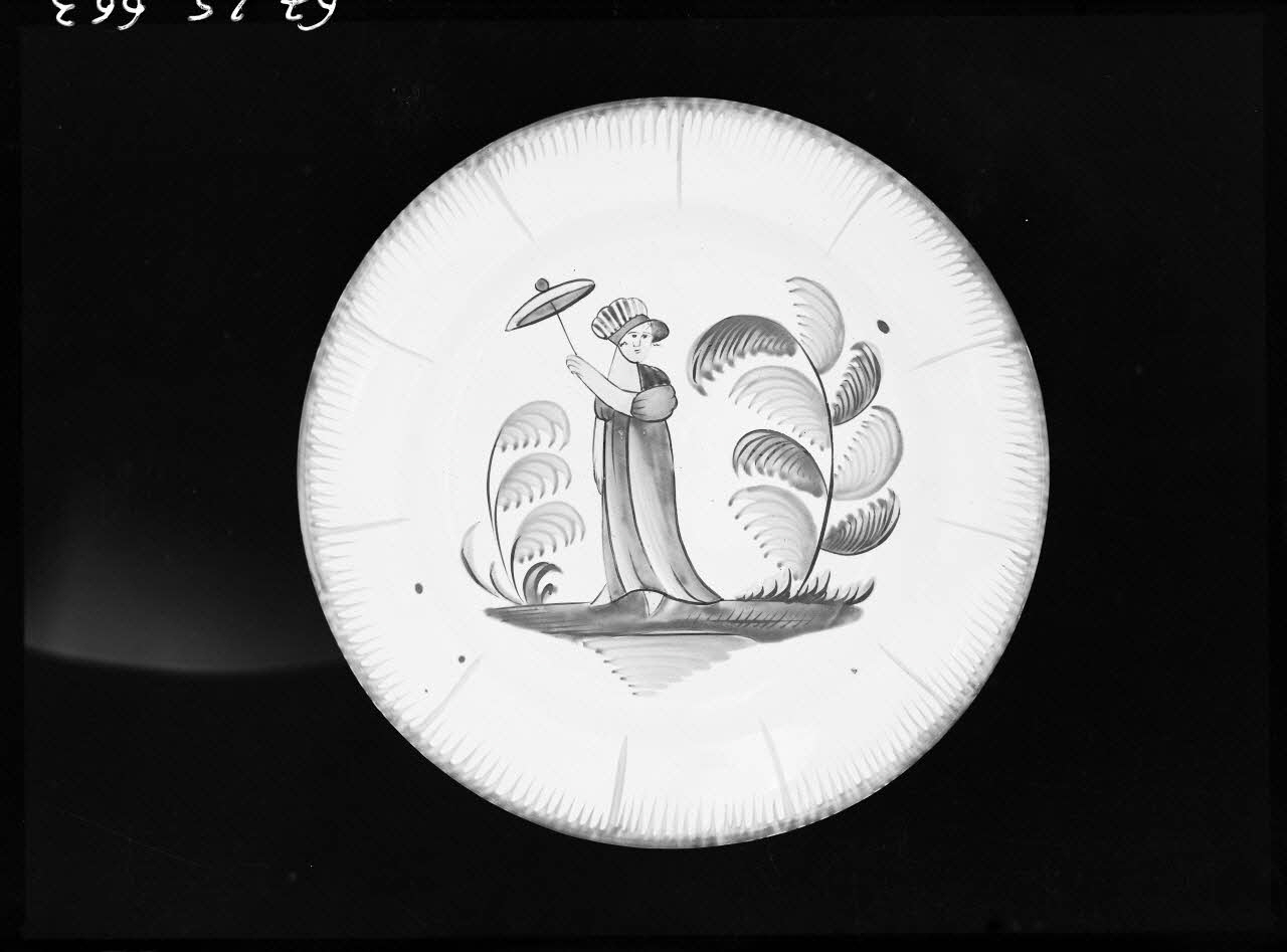 Alain Guey photographie Assiette en faïence polychrome décorée d'une femme avec ombrelle Ile-de-France, France 1967/10/1-1967/12/31 Ph.1967.25.663  Photo