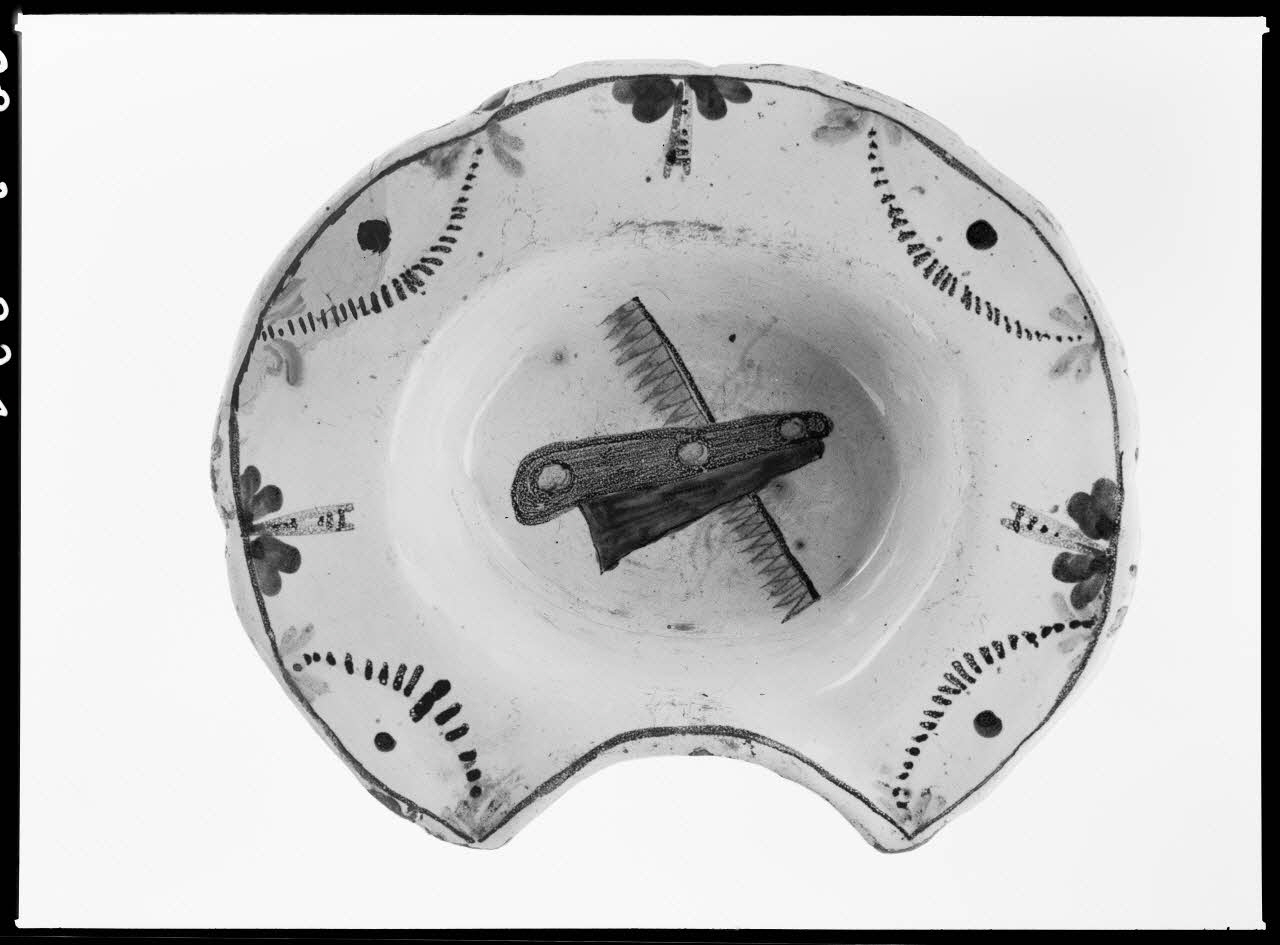 Alain Guey photographie Plat à barbe en terre émaillée de blanc avec dessin d'un rasoir et d'un peigne Ile-de-France, France 1968/2/1 Ph.1968.3.224 Photo