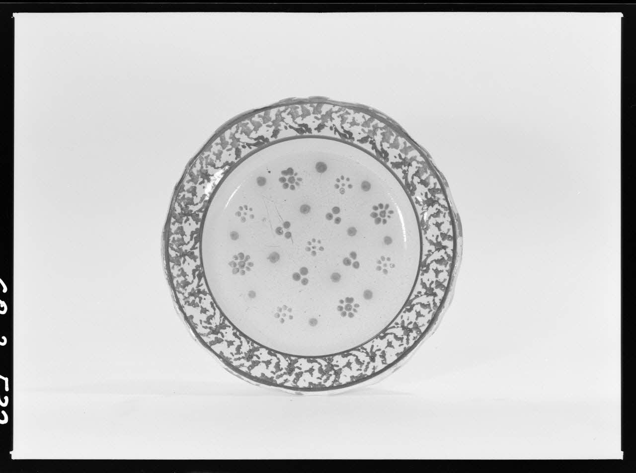 Alain Guey photographie Assiette en faïence. Décor de semis peint en vert, et fleurettes rondes Ile-de-France, France 1968/3/1 Ph.1968.3.532 Photo