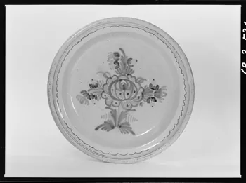 Alain Guey photographie Plat en faïence, à décor polychrome: grosses fleurs dans le fond et rameau fleuri. Provenant d'Indre-et-Loire Ile-de-France, France 1968/3/1 Ph.1968.3.534  Photo