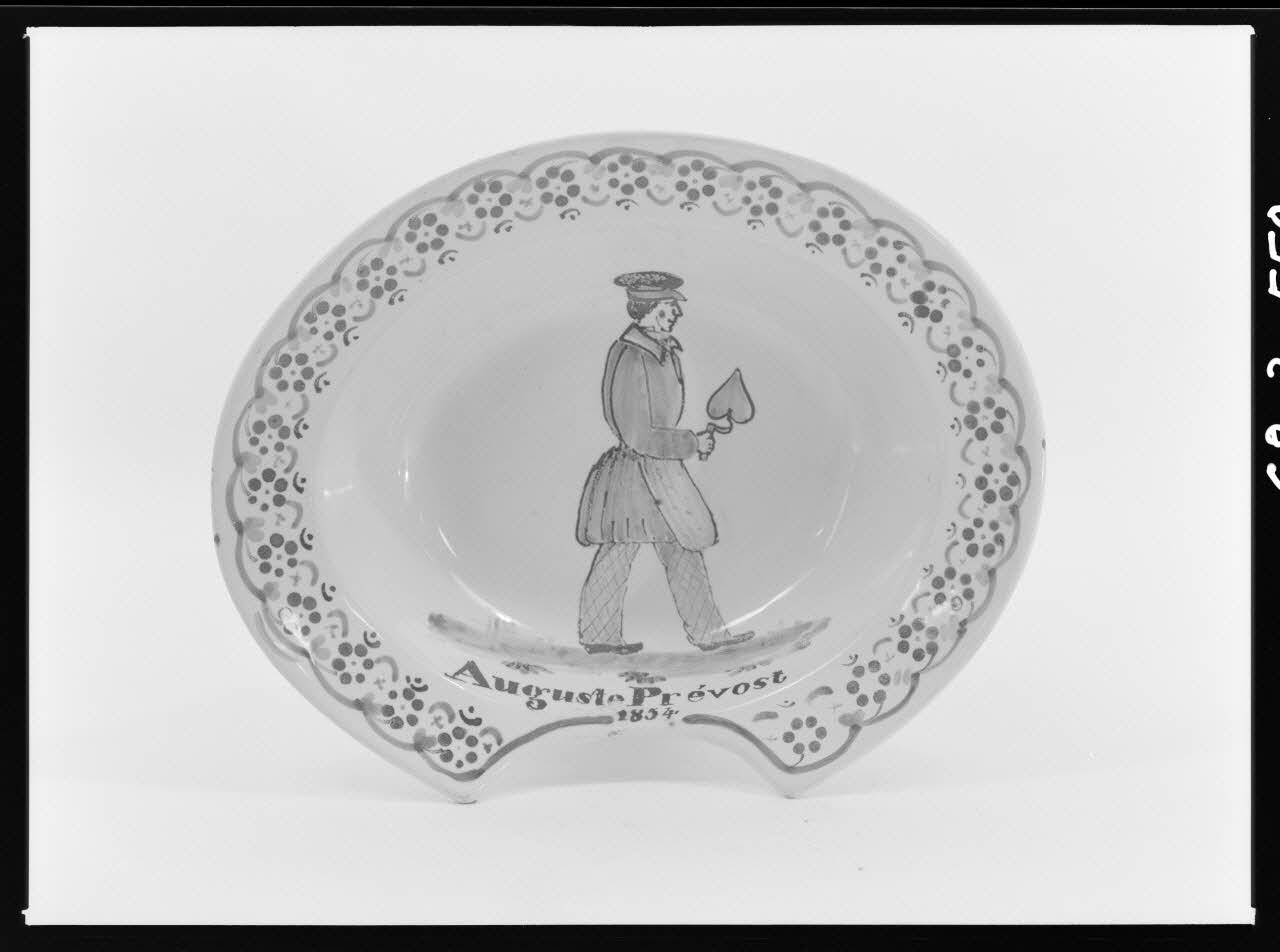 Alain Guey photographie Plat à barbe en faïence polychrome. Décoré au fond d'un homme avec une casquette tenant une truelle, et de l'inscription: "Auguste Prévost. 1854" Ile-de-France, France 1968/3/1 Ph.1968.3.559 Photo