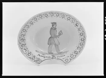 Alain Guey photographie Plat à barbe en faïence polychrome. Décoré au fond d'un homme avec une casquette tenant une truelle, et de l'inscription: "Auguste Prévost. 1854" Ile-de-France, France 1968/3/1 Ph.1968.3.559 Photo
