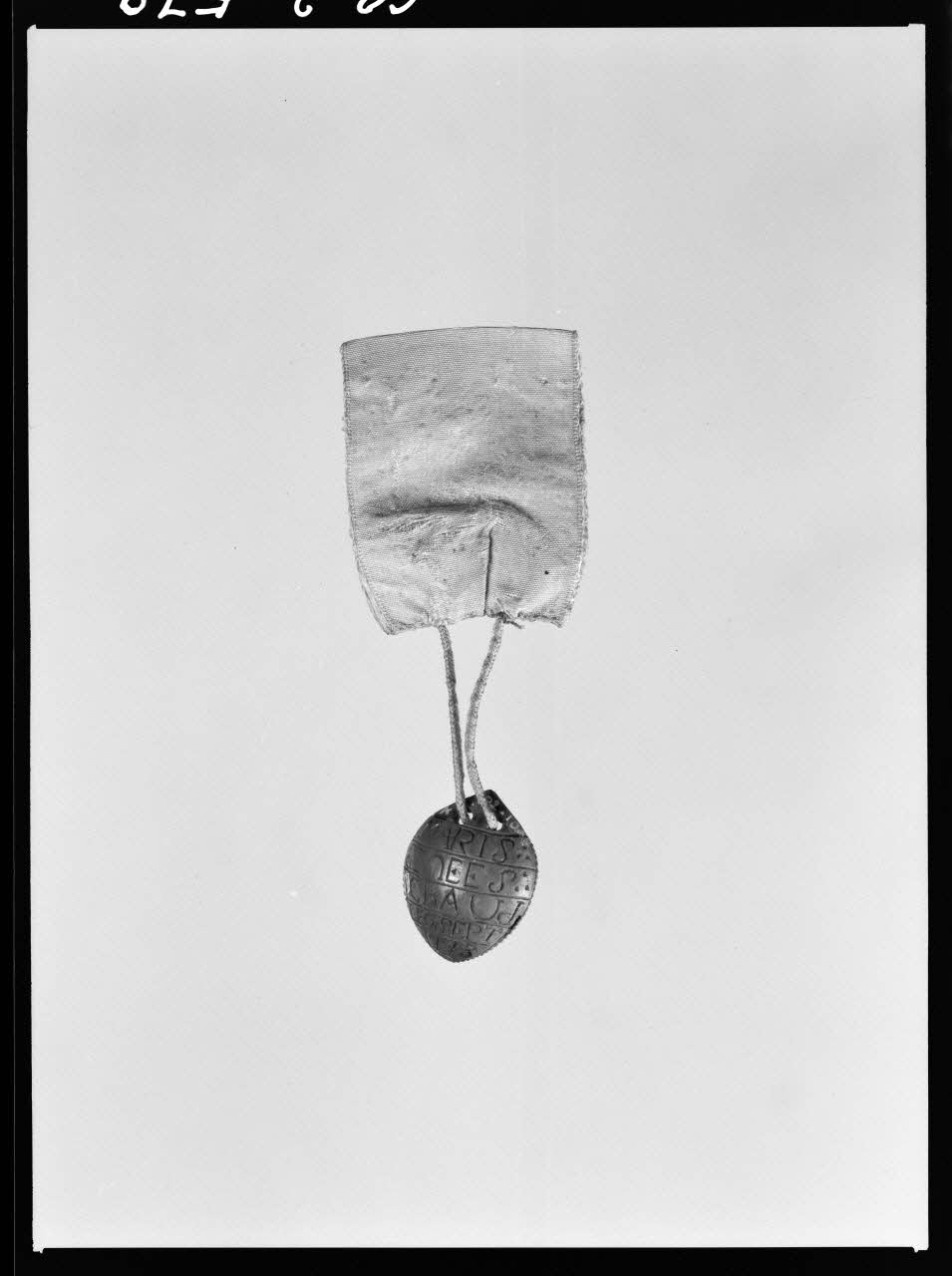 Alain Guey photographie Affiquet constitué d'un noyau, et accroché à un ruban de soie rose. Provenant du Maine-et-Loire Ile-de-France, France 1968/3/1 Ph.1968.3.579 Photo