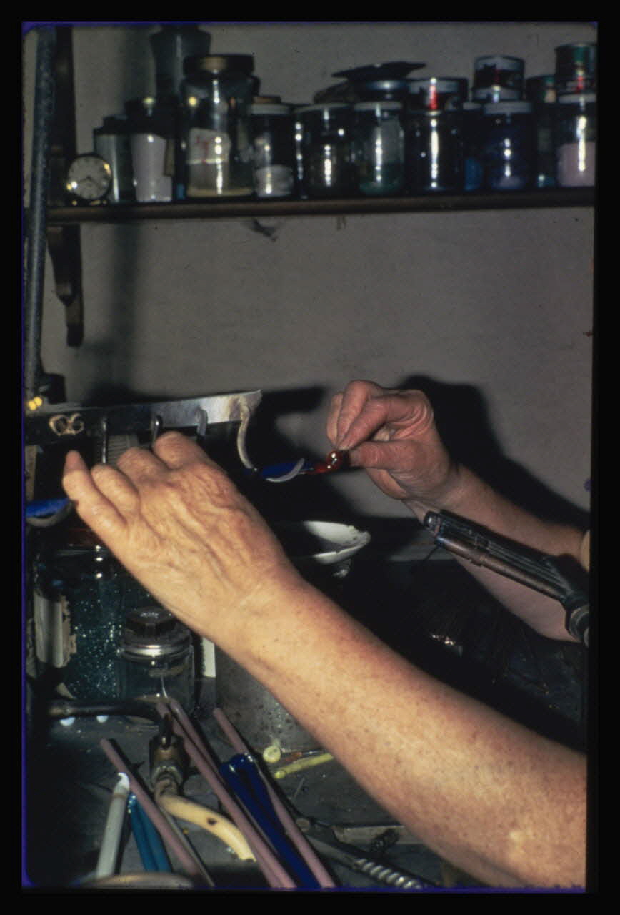 Anonyme photographie Transformation et utilisation du verre. Emailleuse en train de faire des perles artificielles. Détail des mains de l'émailleuse Ile-de-France, France 1967 Ph.1984.26.5 Photo