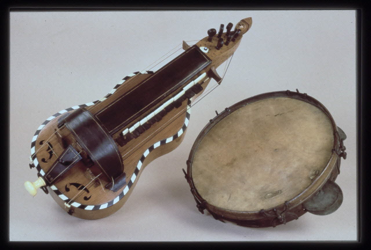 photographie Exposition Musiciens des rues de Paris. MNATP. 18 novembre 1997-27 avril 1998. Commissaire : Florence Getreau. Vielle à roue forme guitare et tambourin sur cadre à sonnailles Ph.2003.21.1 Photo