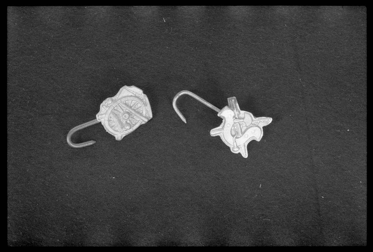 Alain Guey photographie Crochet de tablier de bourrelier fixés dans une plaque découpée représentant un collier. Crochet de tablier de charron fixés dans une plaque découpée représentant un char Ile-de-France, France 1974 Ph.1974.63.65 Photo