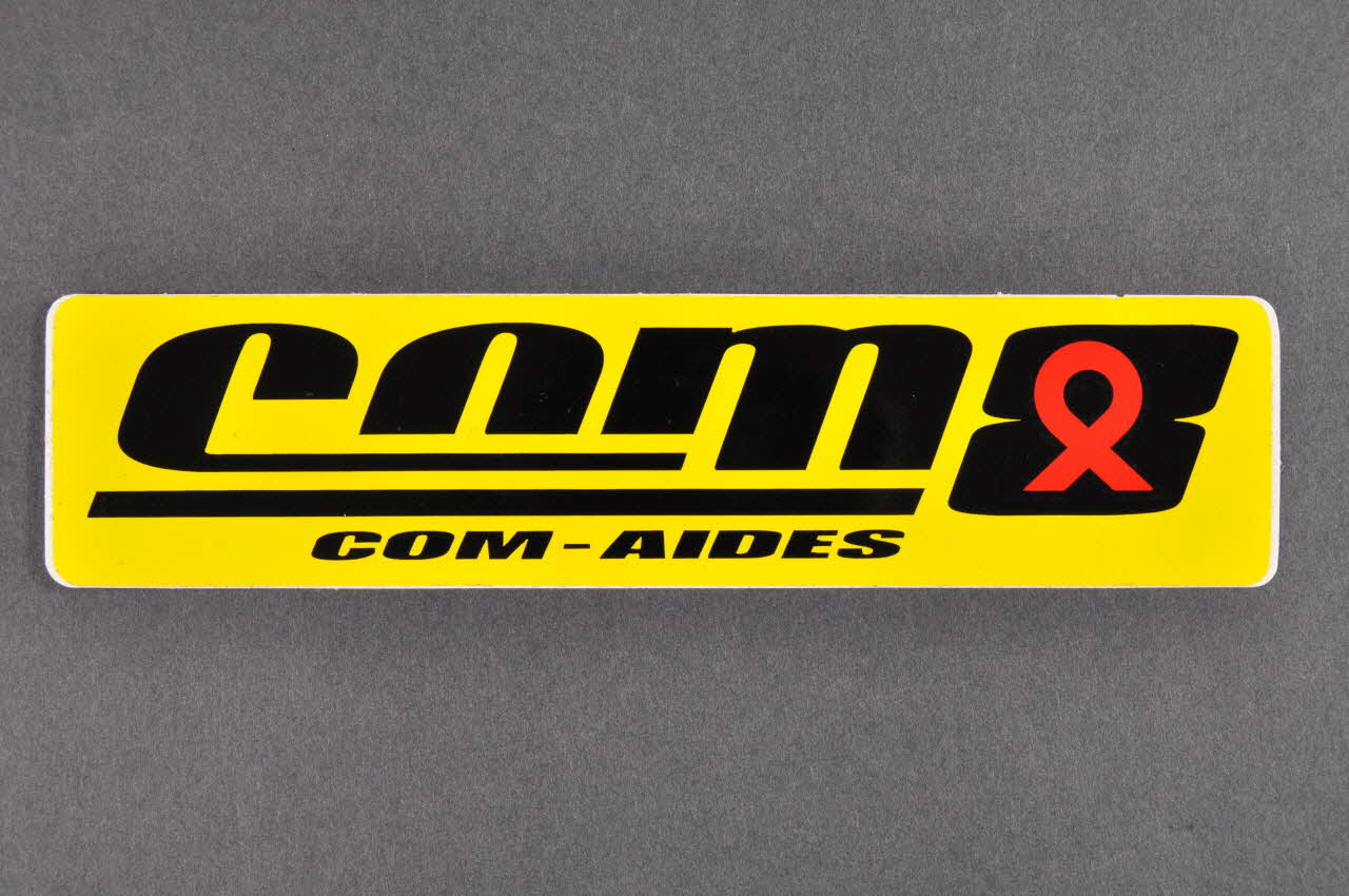 autocollant "Com-Aides" (noir sur jaune) 2005.101.79 Photo Mucem