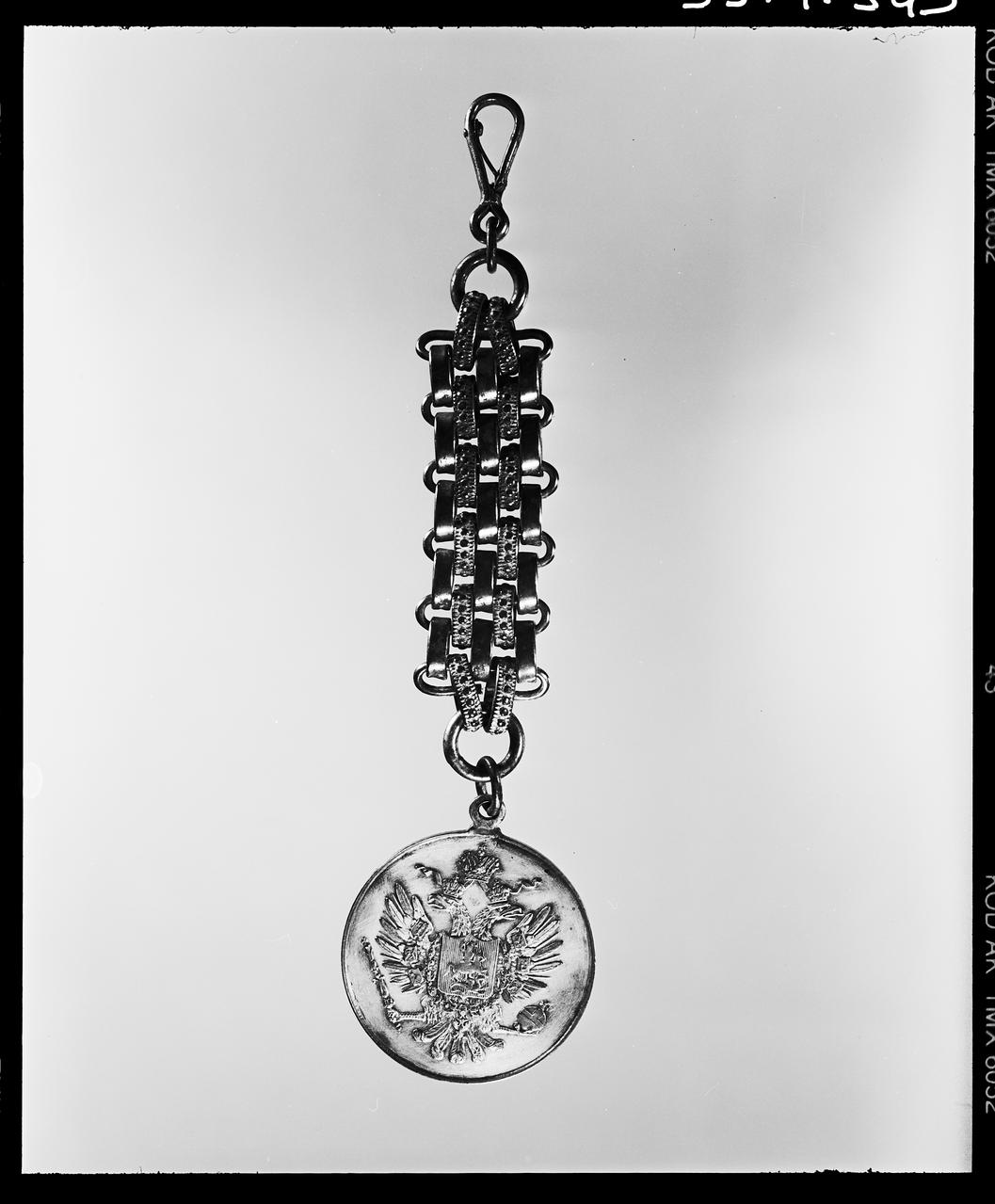 Danièle Adam photographie Chaine de montre et médaille. métal argenté. Decor : alliance franco-russe. Fin 1905 Ile-de-France, France 1993 Ph.1993.1.349  Photo