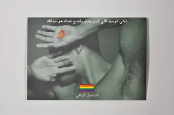 carte postale homme se cachant le visage tenant un préservatif, drapeau arc en ciel, préservatif collé au verso 2005.119.47  Photo Mucem