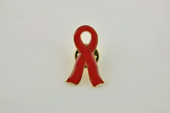 Pin's ruban rouge Pin's ruban rouge encerclé de doré, commentaire en arabe et en anglais 2005.119.48.1-3 Photo Mucem