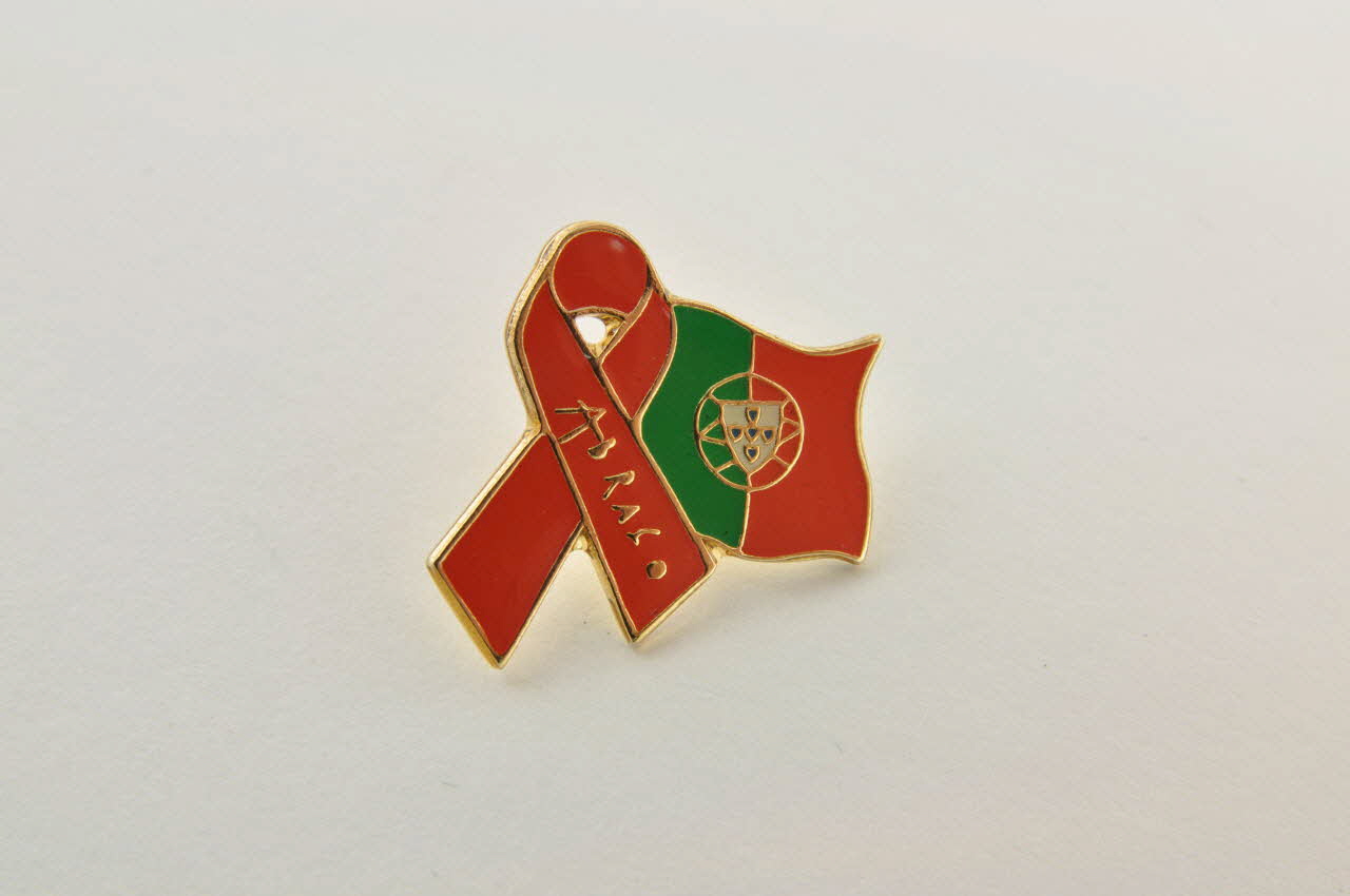 Pin's ruban rouge Pin's   ruban rouge entourant drapeau du Portugal 2003.109.244.1-2 Photo Mucem