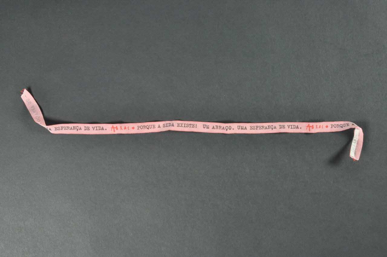 Ruban bracelet Ruban rose "Abraço. Porque a sida existe. Un abraço. Una esperança de vida" (Abraço. Parce que le sida existe. Un baiser. Une espérance de vie) 2003.109.261 Photo Mucem