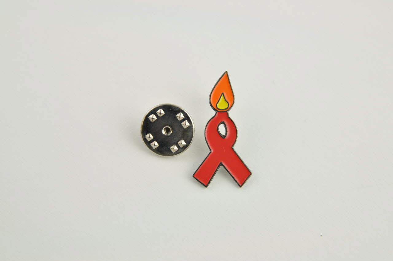 ILGA Portugal Pin's ruban rouge Pin's ruban rouge avec flamme Portugal 2003 2003.110.17.1-2 Photo Mucem