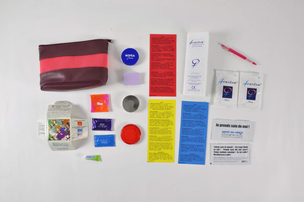 Groupe Sida Genève Stylo bille Trousse contenant 1 boite de crème nivéa, 1 boite ronde porte préservatif, 1 préservatif masculin, 1 miroir, 2 lingettes rafraichissantes à usage intime, 2 préservatifs féminins, 1 bloc de post it, 3 fiches plastifiées avec adresses utiles, 1 dépliant mode d'emploi du fémidon, 1 tube de crème cicatrisante, 1 stylo bille Lorraine, France 2005 2005.171.3.6 Photo Mucem