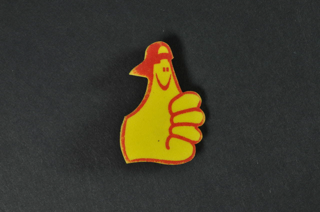 broche Main jaune dont le pouce est recouvert par un préservatif 2003.125.308 Photo Mucem