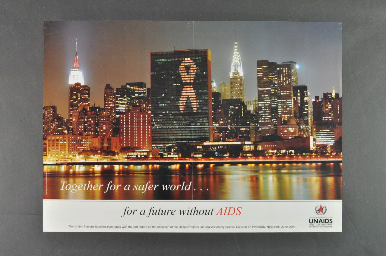Onusida affiche Illumination du siège des Nations Unies avec le ruban rouge, à l'occasion de l'Assemblée générale des Nations unies, Session spéciale sur le VIH/Sida, New York, juin 2001 Lorraine, France 2001/6 2004.206.3 Photo Mucem