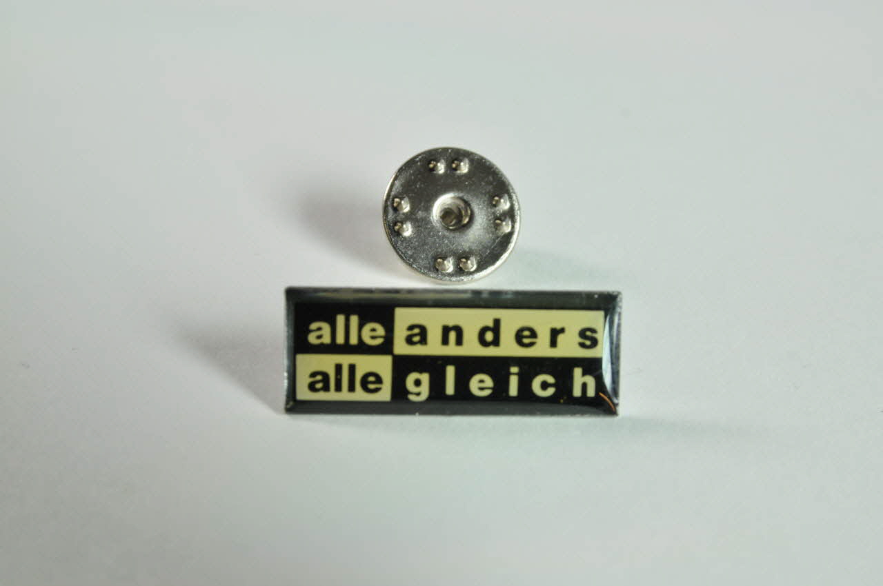 pin's Pin's "Alle anders alle gleich" (Tous différents. Tous égaux) 2003.125.594.1-2 Photo Mucem