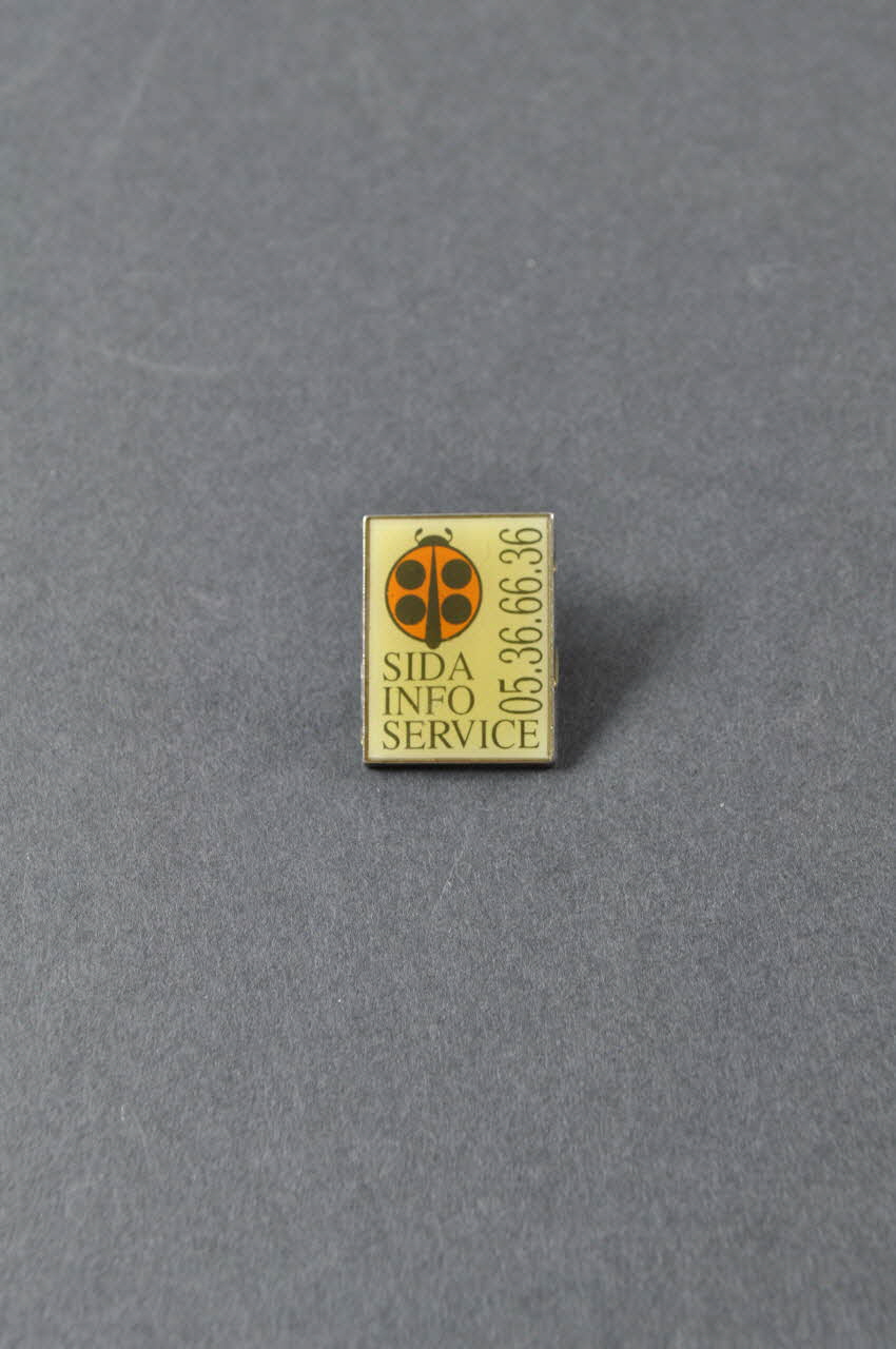 pin's Pin's "Sida info Service" 2003.125.598 Photo Mucem