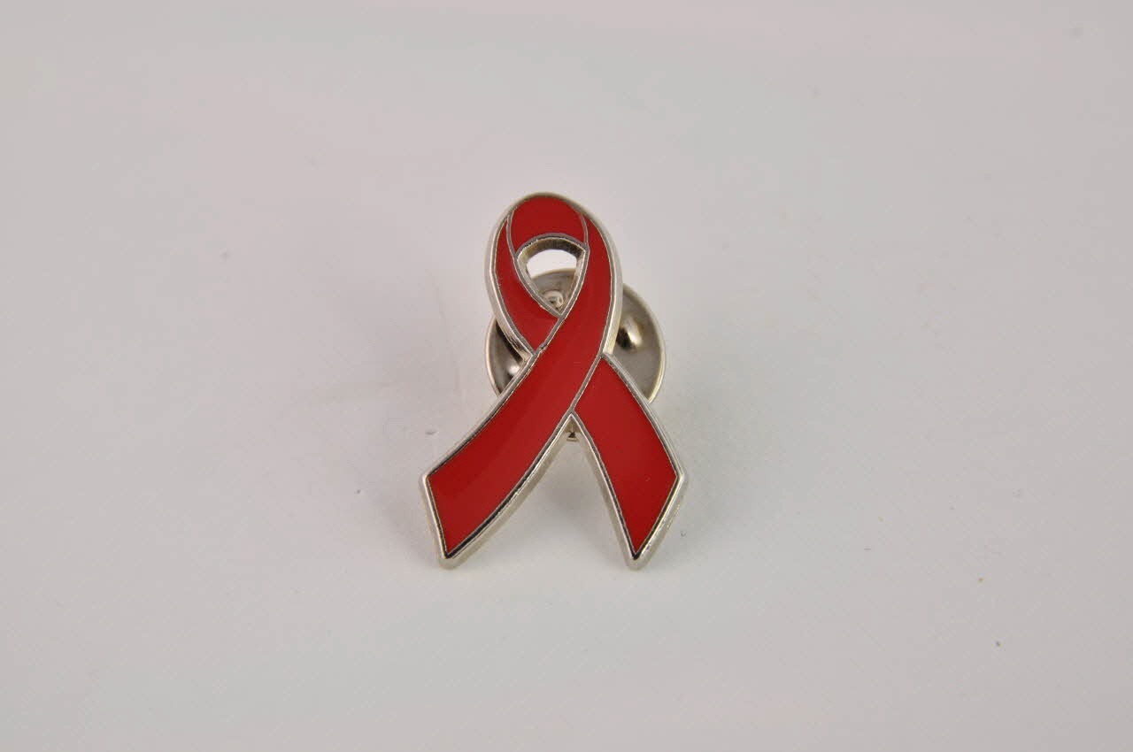 Comité 1er Décembre Pin's ruban rouge Pin's Ruban rouge surligné par une ligne argentée Espagne 2002 2003.93.28.2.1-2 Photo Mucem