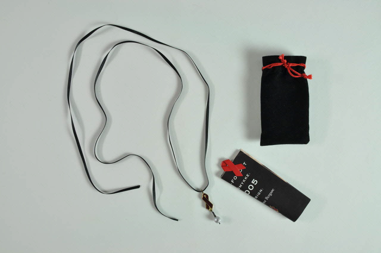 pendentif Pendentif avec ruban rouge et perle dans pochette (Vedhaeng med kaede) Danemark 2005 2005.88.7.1-4 Photo Mucem