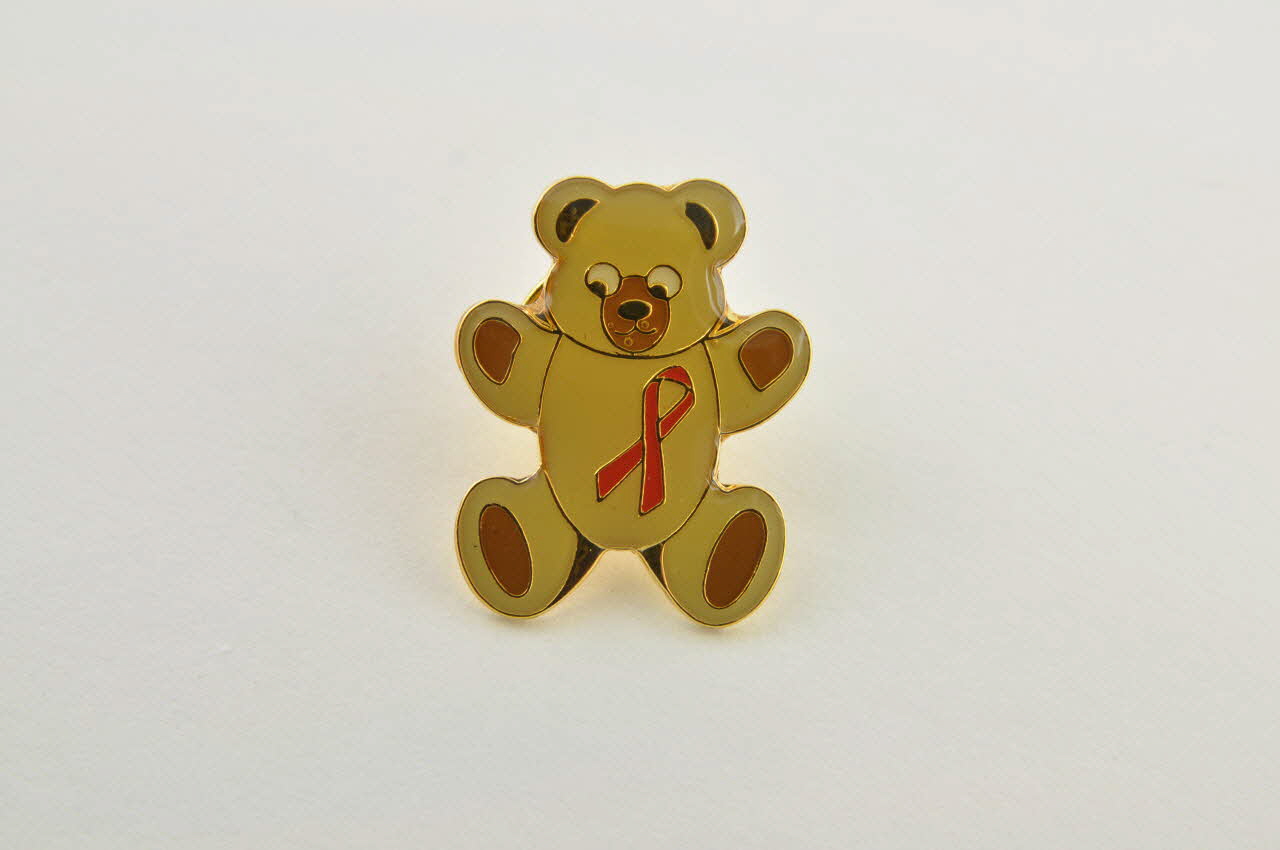 Deutsche Aids-Hilfe pin's ours brun avec ruban rouge Allemagne 2003 2003.97.42.1-2 Photo Mucem