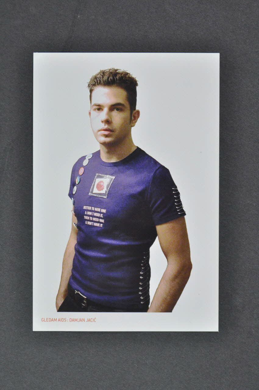 carte postale "Gledam AIDS" par le designer de mode Damjan Jacic : Tee shirt avec préservatif :"Better to have one & don't need it than to need one and don't have it" (Il vaut mieux en avoir et ne pas en avoir besoin qu'en avoir besoin et ne pas en avoir) Croatie 2005 2006.66.15 Photo Mucem