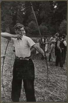 Madame Cartier photographie Dans le parc. Fête de Sylvie et des tireurs d'arc organisée par la Fédération folklorique d'Ile-de-France. La flèche vient de partir. L'arc est détendu Picardie, France 1938/6/19 Ph.1941.97.11  Photo