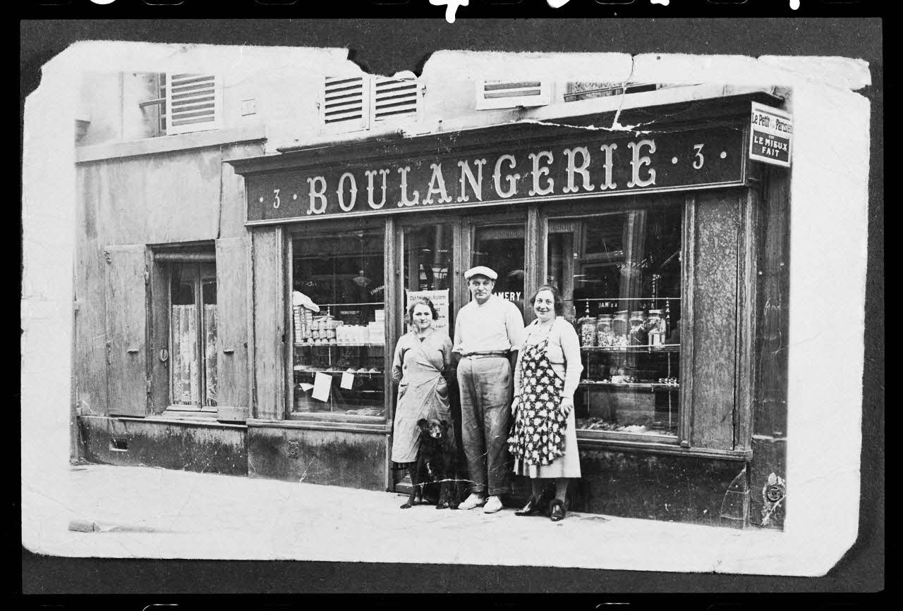 photographie Couple avec un chien devant la devanture d'une boulangerie. 1933 Ph.1986.40.1 Photo