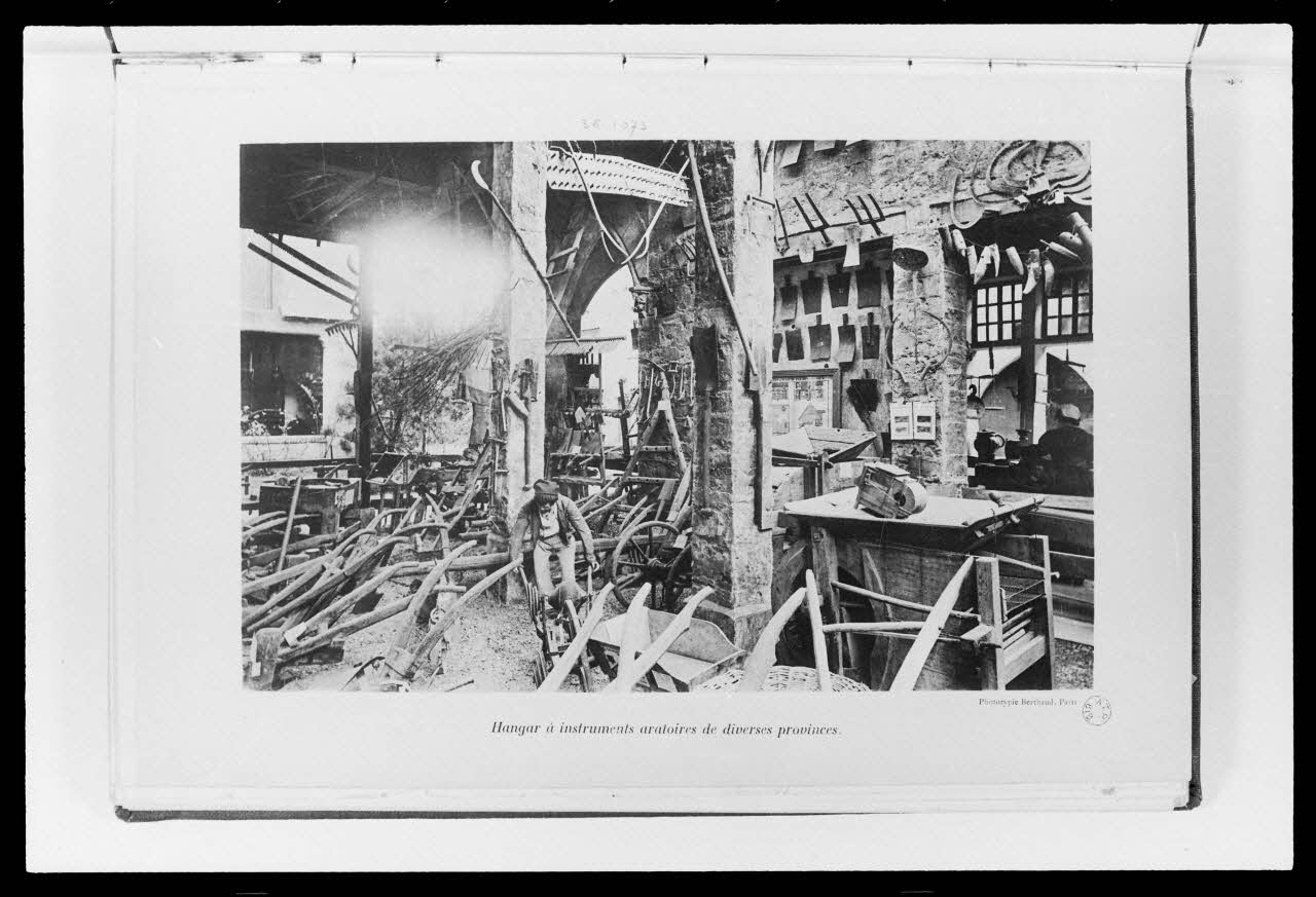 photographie Photographie d'une reconstitution d'un ensemble agricole à l'exposition de 1900: hangar et instruments aratoires. Musée rétrospectif du groupe 7, rapport de J. Sain Ph.1986.58.4 Photo