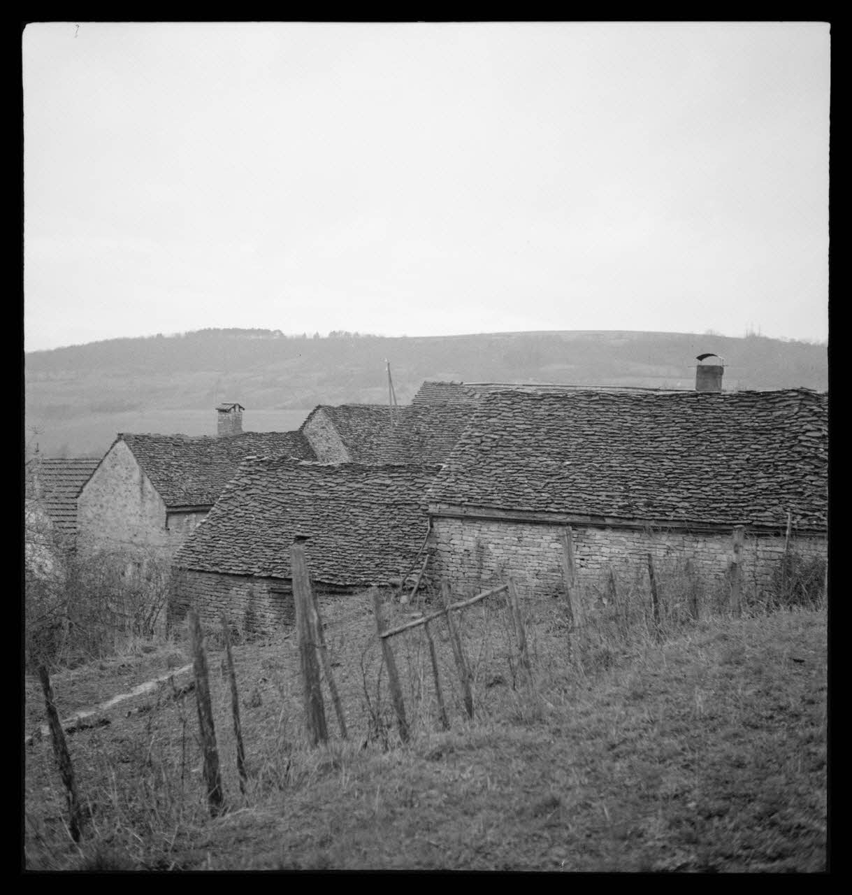 Marc Augier photographie Groupe de vieilles maisons couvertes en pierres plates et laves. Cheminée couverte en lave. Une lave sur quatre pieds Bourgogne, France 1937/2/1 Ph.1937.86 Photo