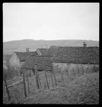 Marc Augier photographie Groupe de vieilles maisons couvertes en pierres plates et laves. Cheminée couverte en lave. Une lave sur quatre pieds Bourgogne, France 1937/2/1 Ph.1937.86  Photo