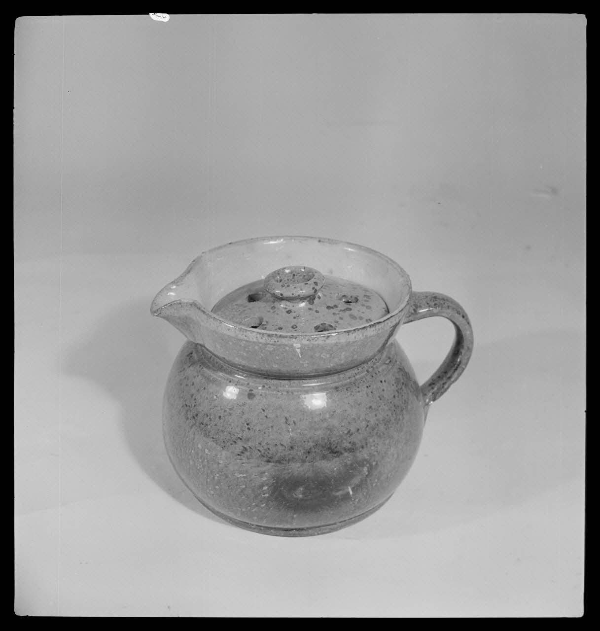 Gérard Franceschi photographie Pot à lait avec couvercle percé de six trous. Diamètre de 160 millimètres. Terre en vernis jaune. Provenance : Soufflenheim, Bas-Rhin France 1942 Ph.1942.165.343 Photo