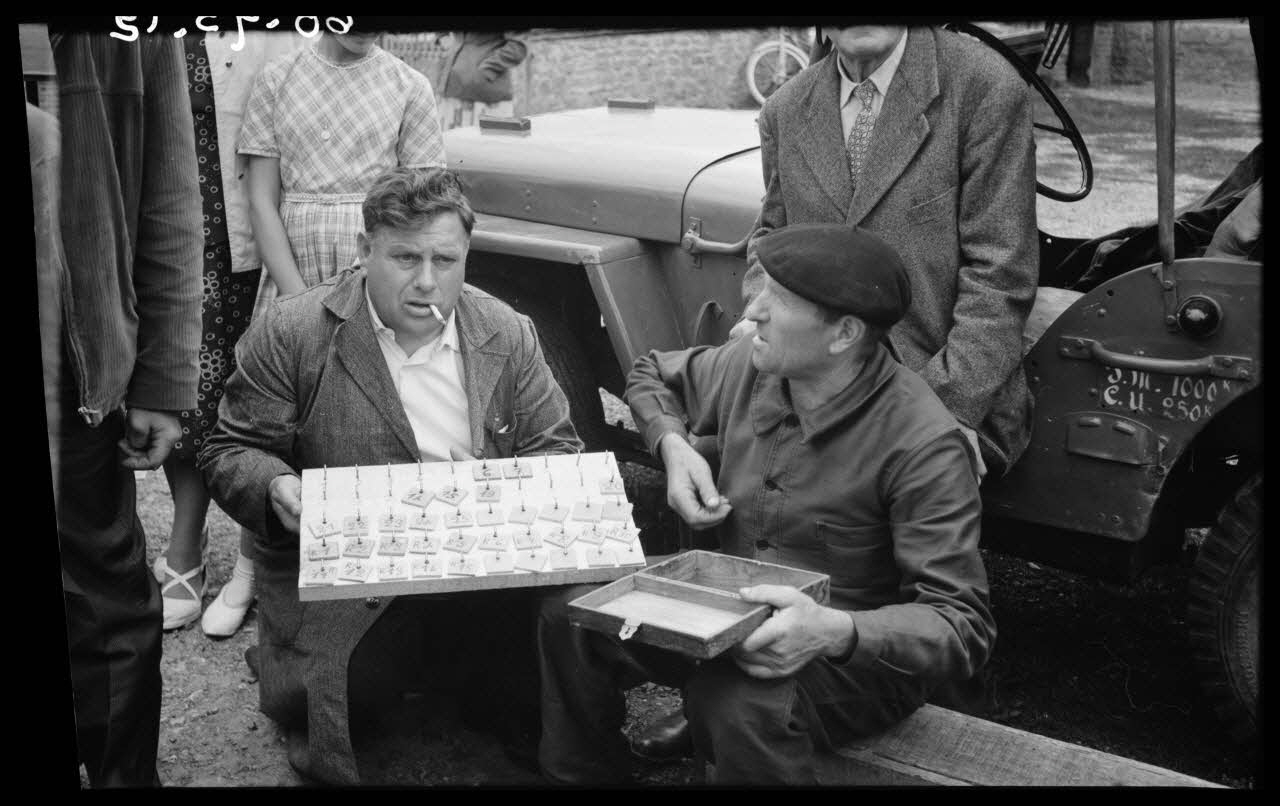 Boucher photographie Fête patronale. Jeu à trois quilles : tableau pour le contrôle des enjeux. Chaque joueur reçoit au moment de jouer un jeton numéroté en échange de l'enjeu qu'il verse Basse-Normandie, France 1960/7/24 Ph.1960.93.12 Photo
