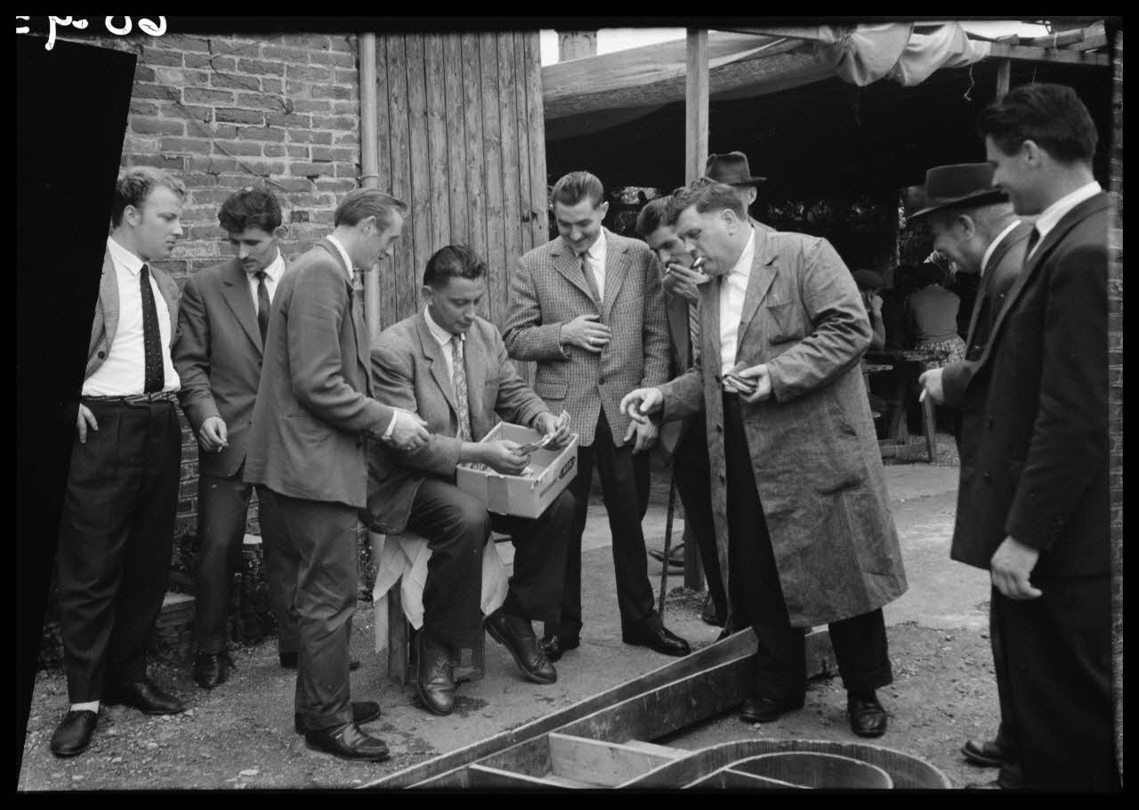Boucher photographie Jeu de bastringue : levée du pot (totalité des gains versés) qui est remis au gagnant par le tenant du jeu. Le gagnant vient de recevoir son gain Basse-Normandie, France 1960/7/24 Ph.1960.93.24 Photo